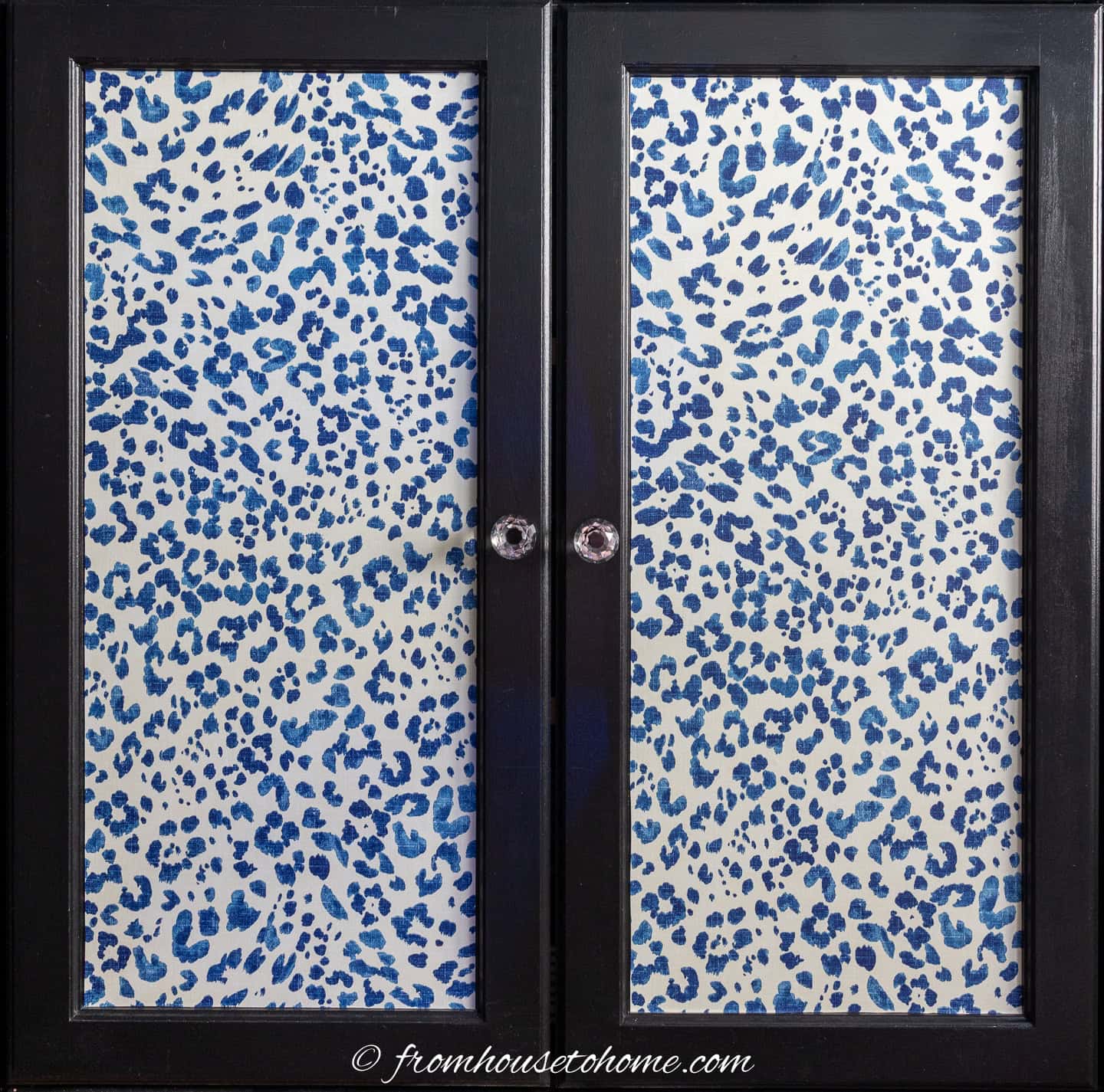 kitchen cabinet doors covered with blue leopard print wallpaper and crystal knobs