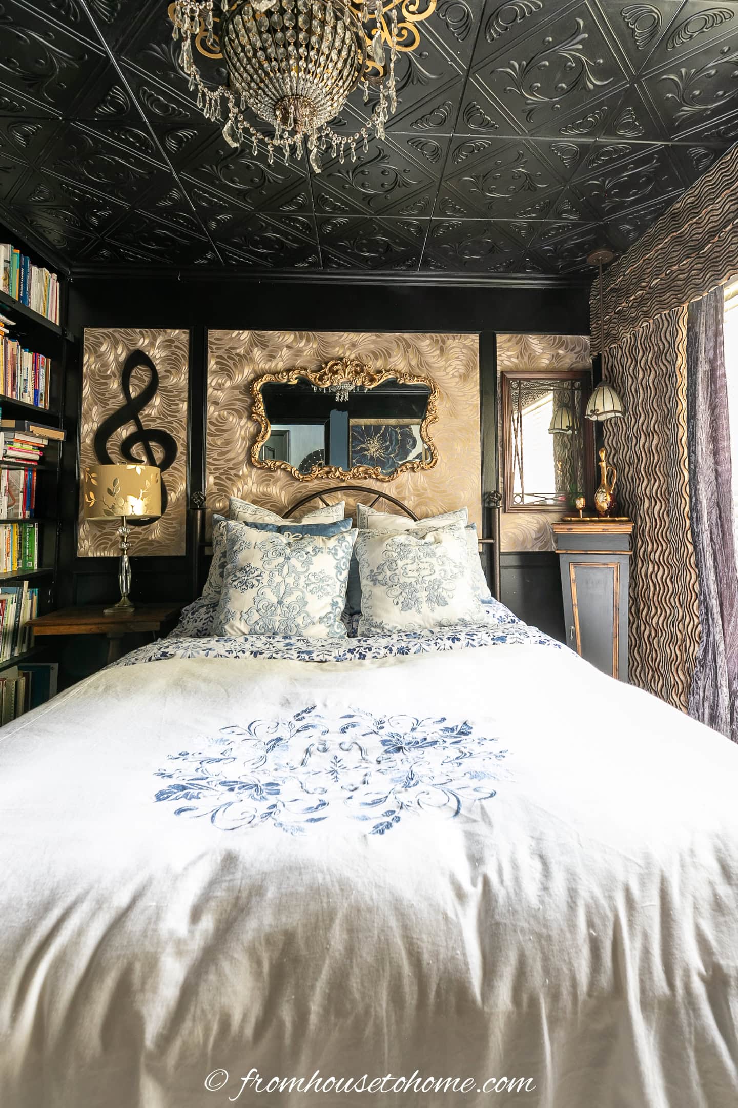 A small bedroom with the walls and ceiling painted in black semi-gloss paint