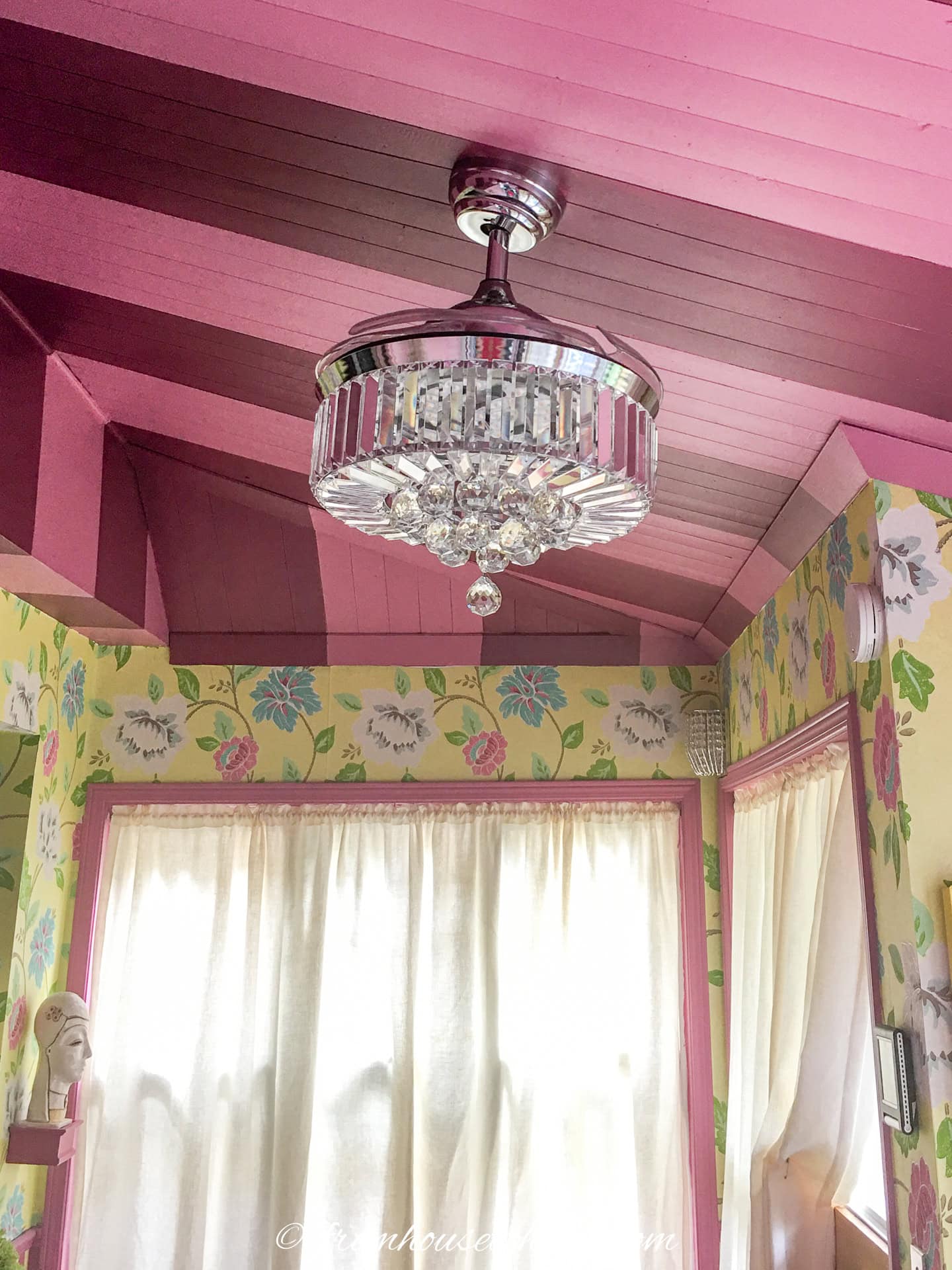 A crystal light fixture in a pink and yellow kitchen