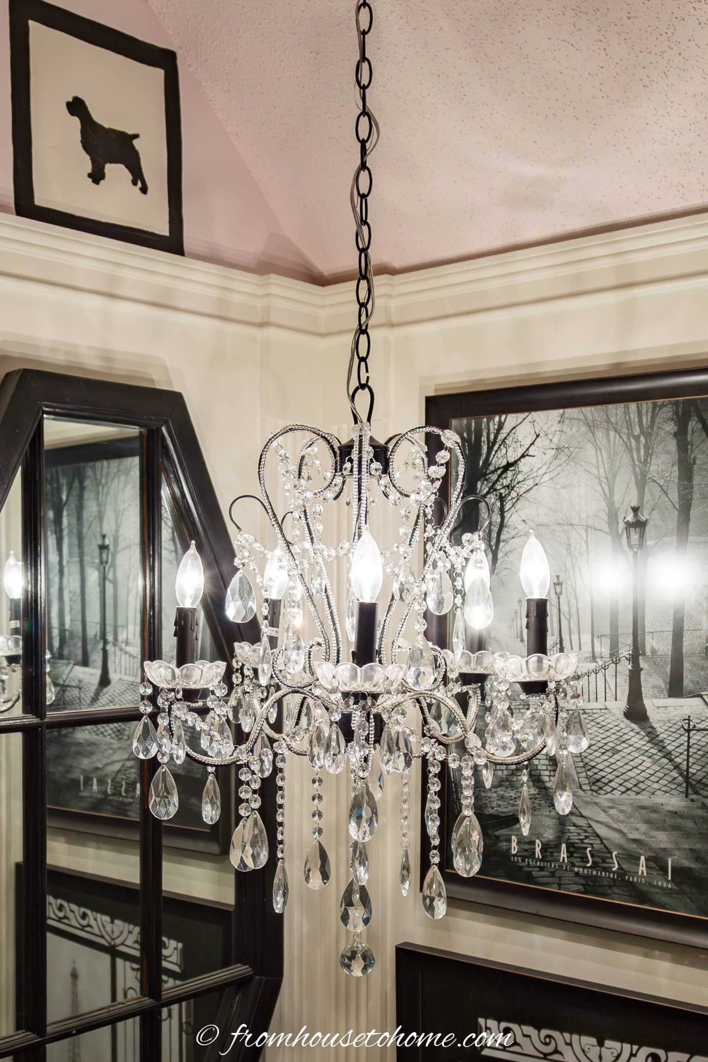 close up of a chandelier in front of gallery wall