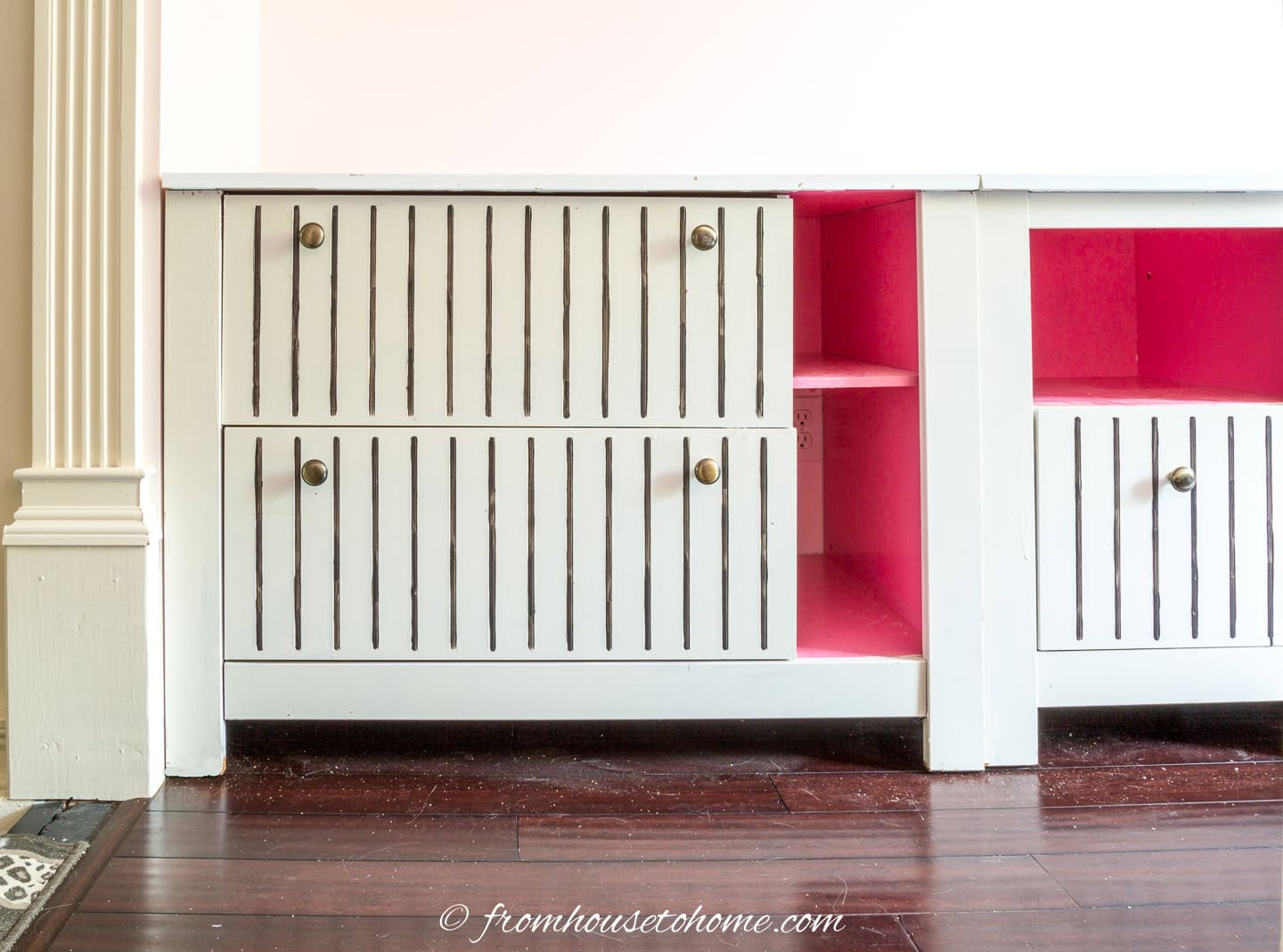 Filing cabinets painted white with hot pink interiors and black pin stripes on the drawers