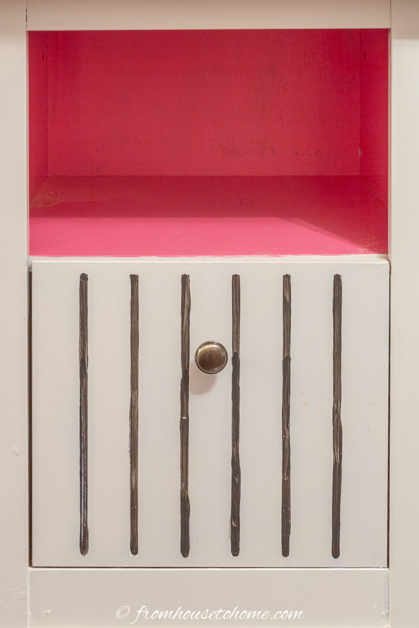 a glam filing cabinet that has been painted white, with a hot pink interior and black pin stripes on the drawers