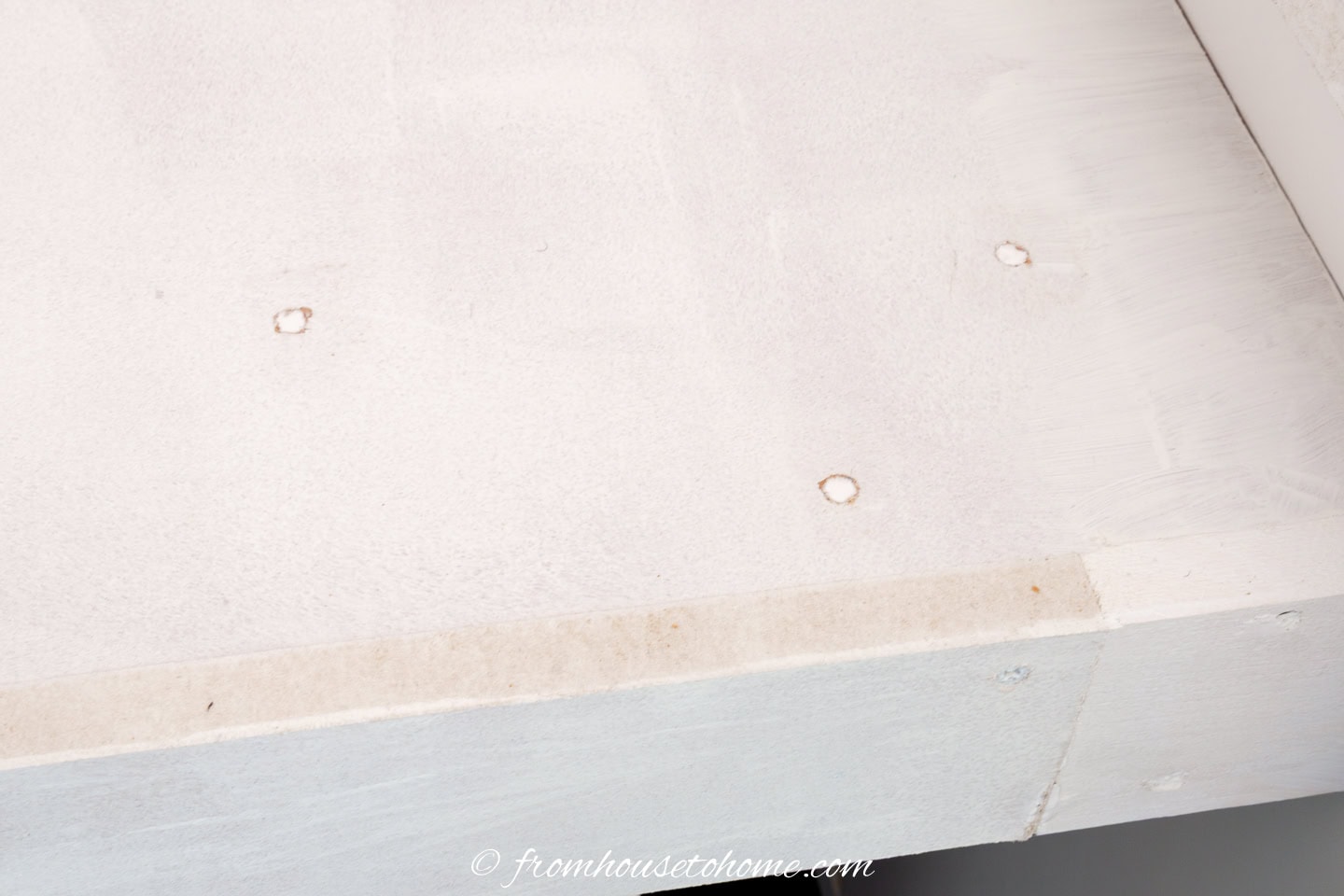 A counterop with holes and cracks filled with caulk