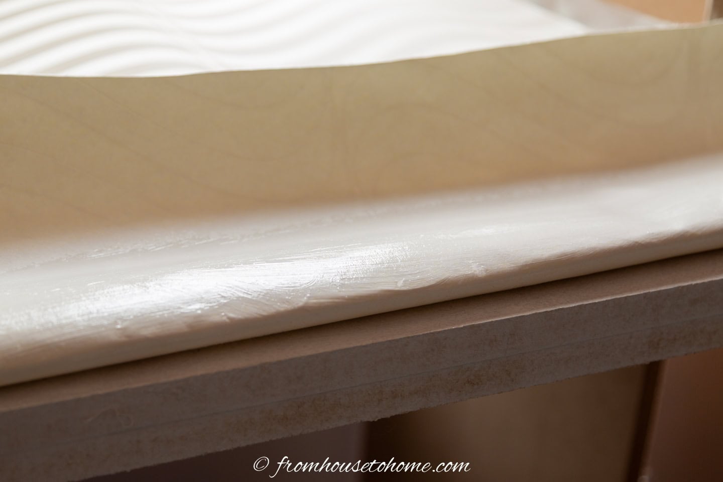 Wallpaper with extra glue on it ready to be stuck to the overhang of a countertop