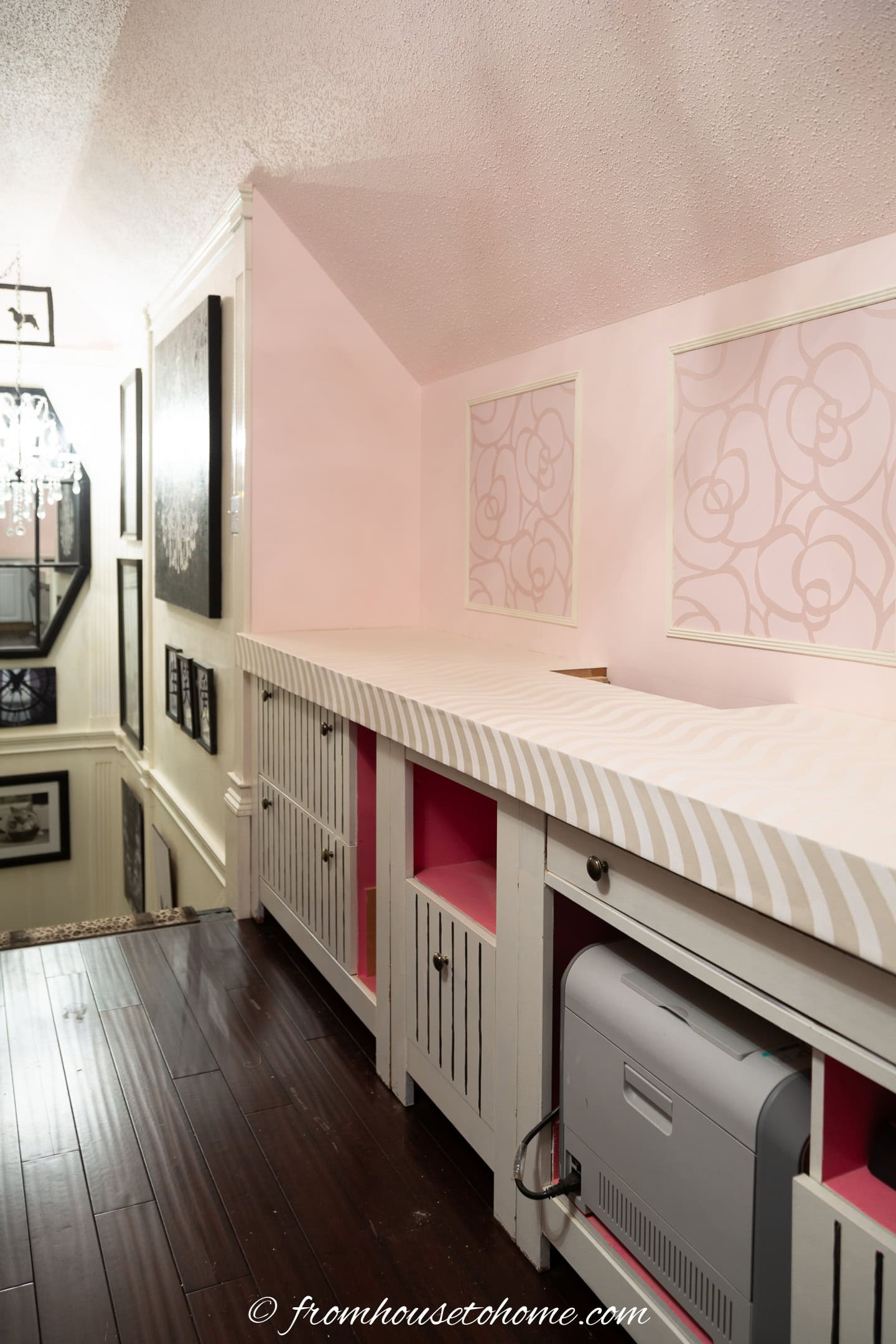 A white wallpapered countertop in a pink and white home office