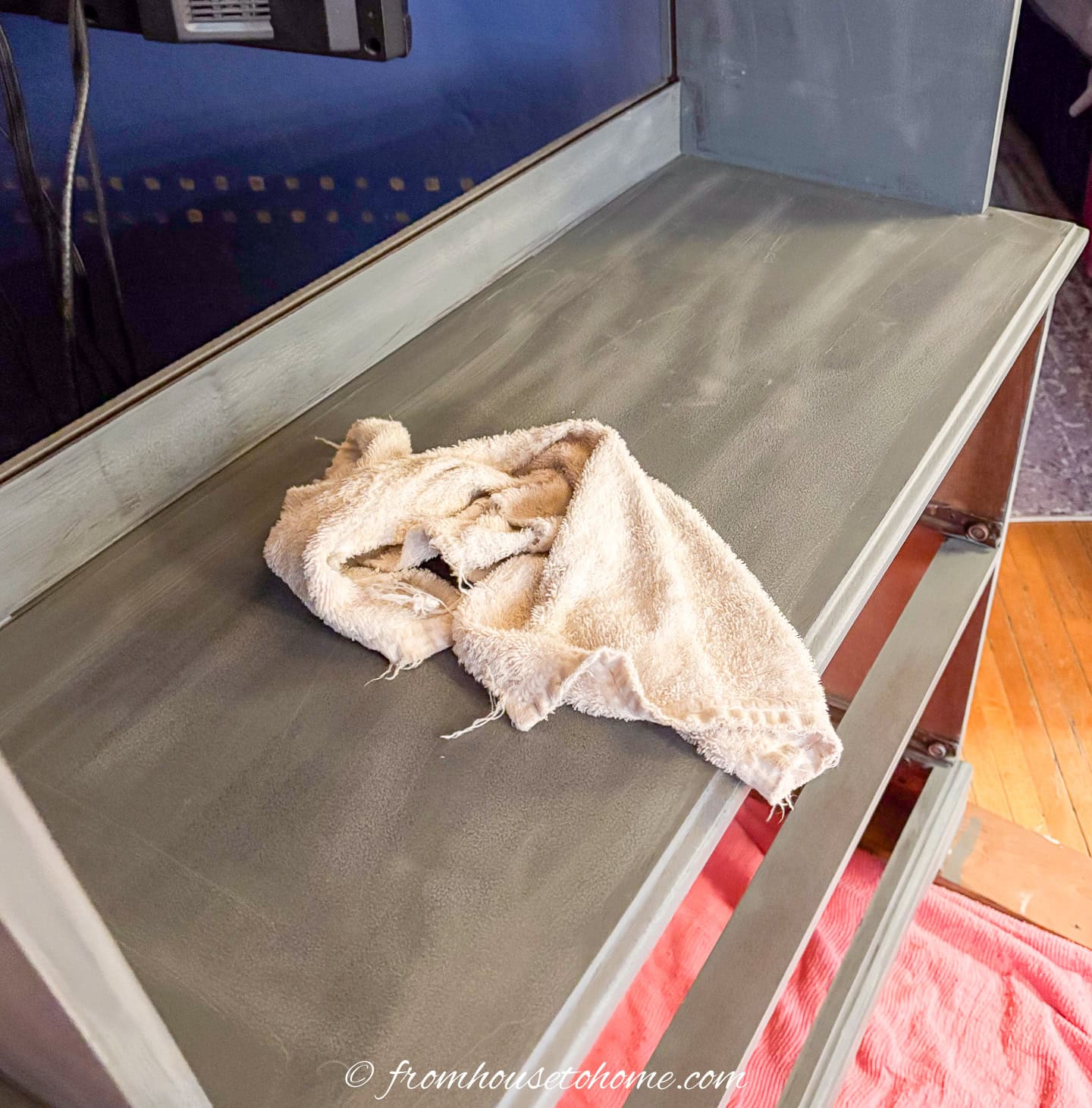 Bookshelf being wiped down with a damp cloth after being primed and sanded