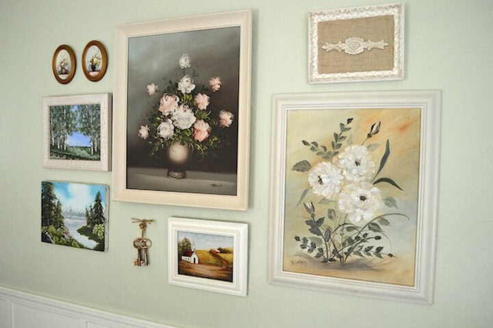 A collection of thrifted art pieces in a gallery wall display