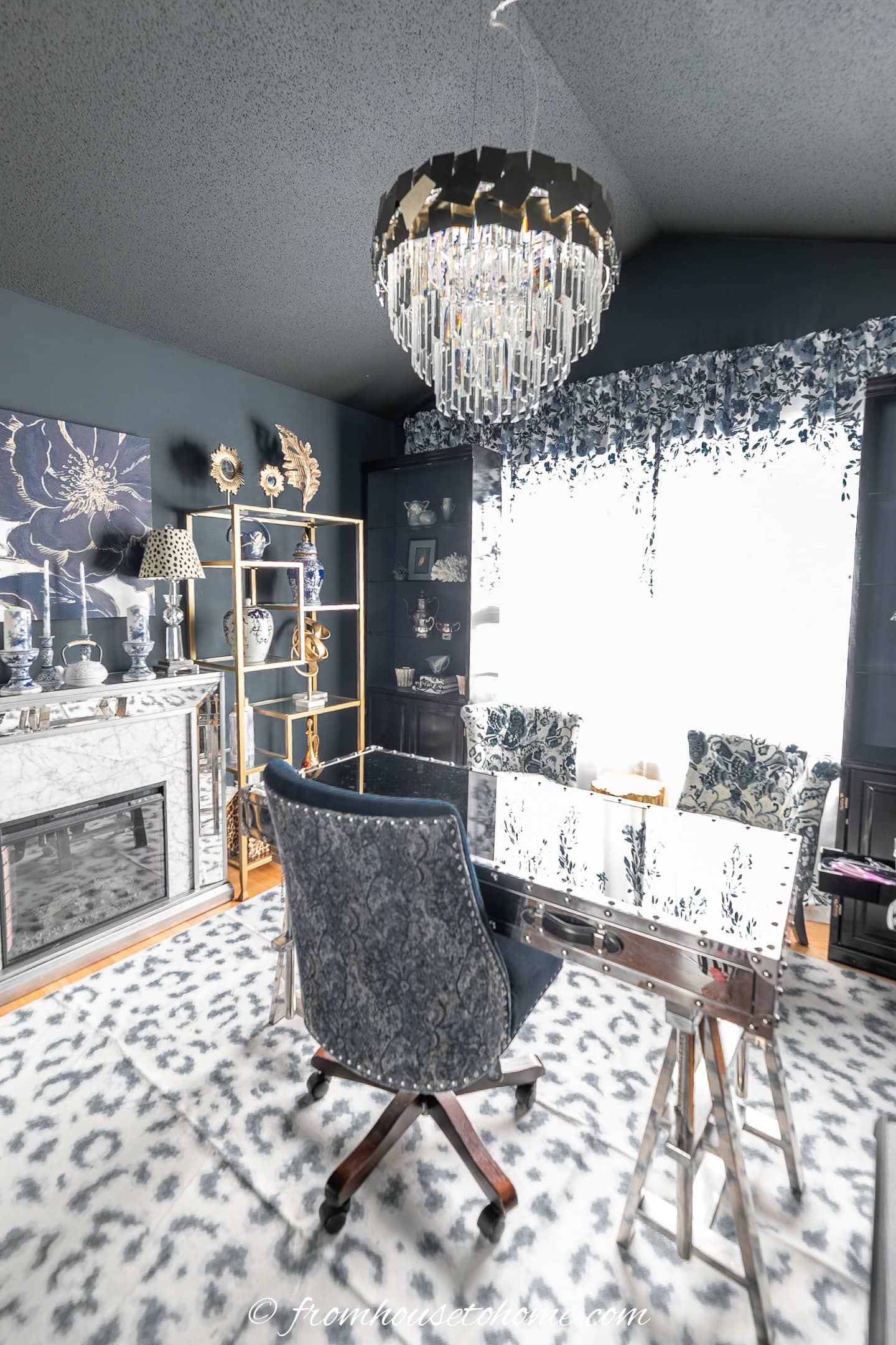 A dark blue and white home office with gold shelves and an electric fireplace
