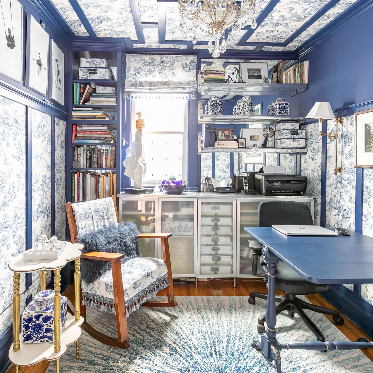 A small blue and white home office decorated in toile walls and ceiling