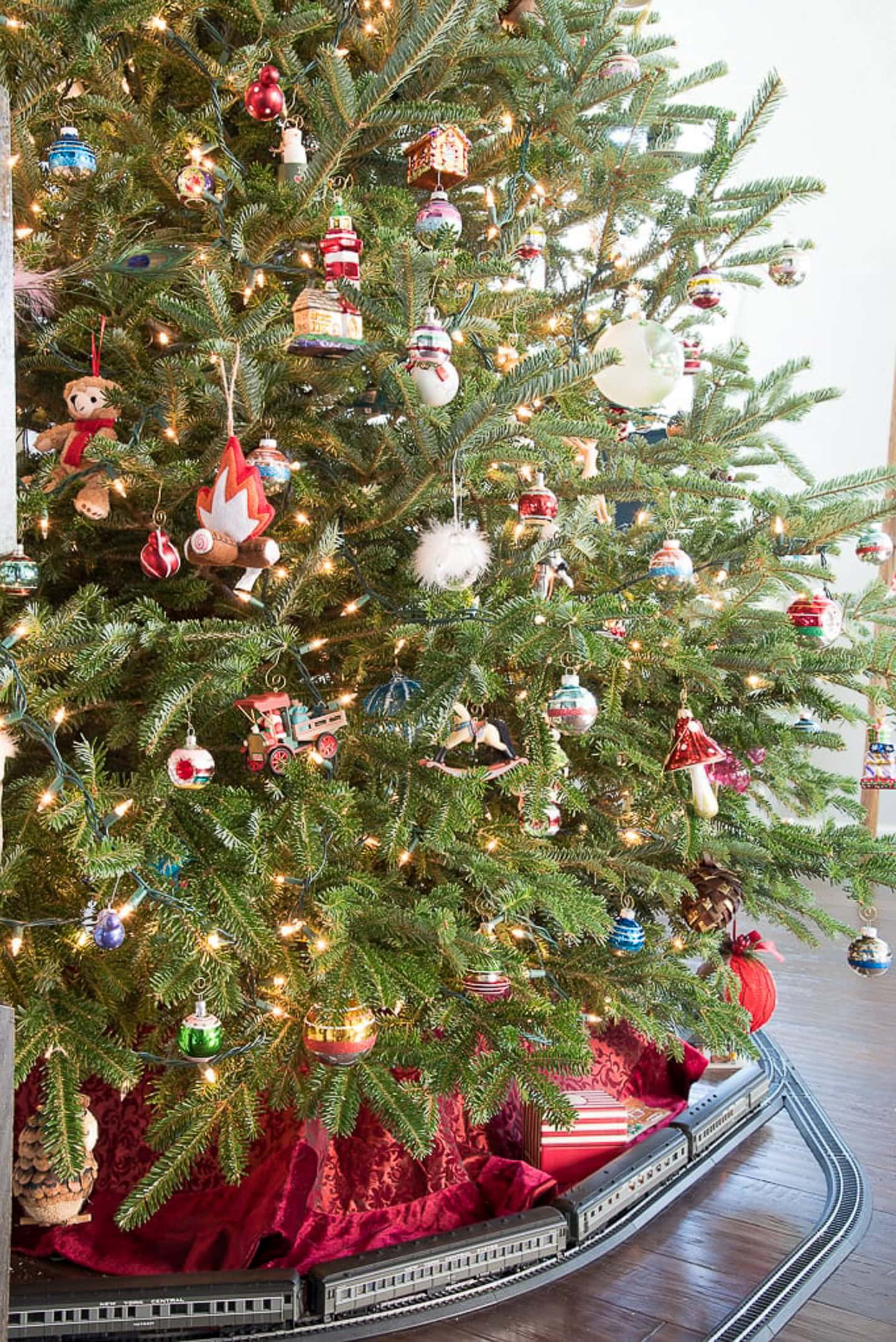 A fresh Christmas tree with a toy railroad installed around the bottom of it