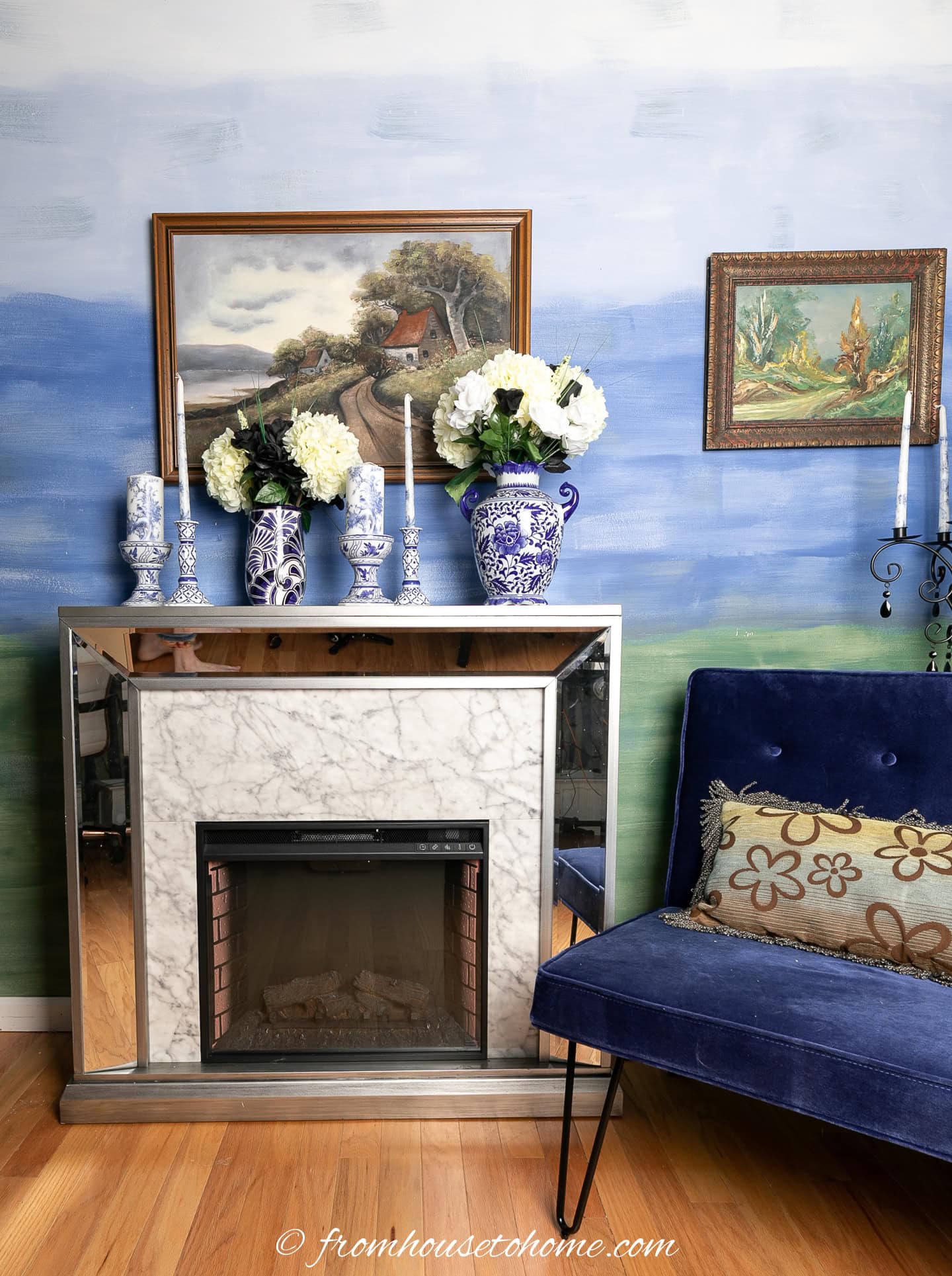 A fireplace and large chair in front of an ombre accent wall