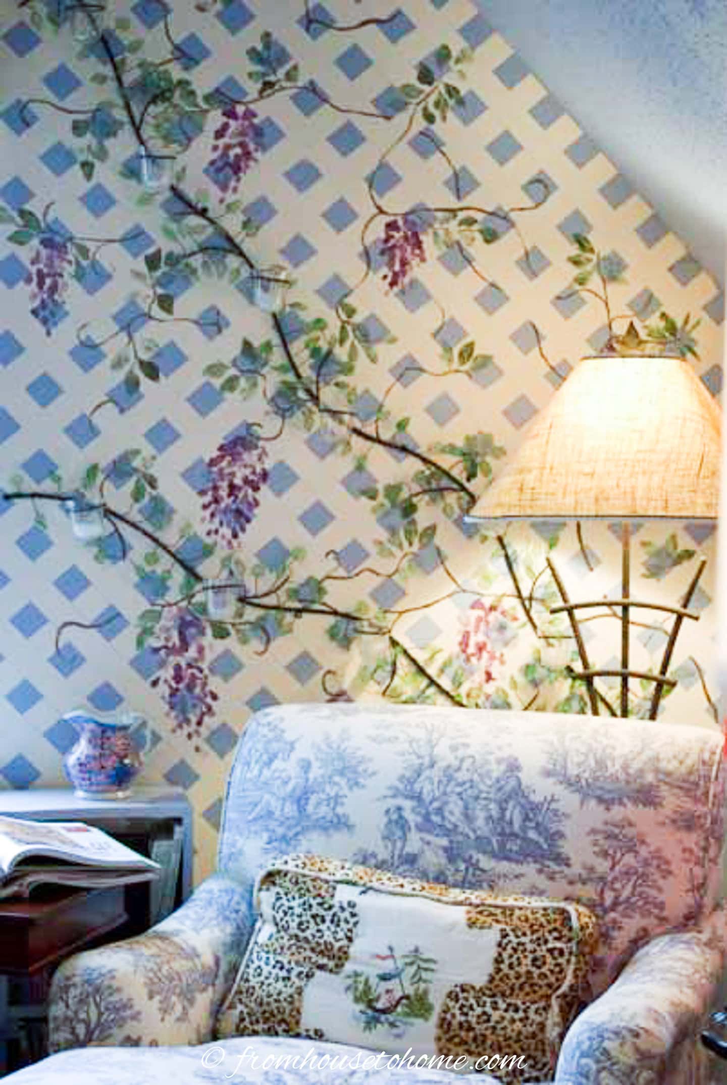 A trellis with Wisteria painted on the wall behind a chaise