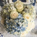blue and white tablescape centerpiece with hydrangeas and roses